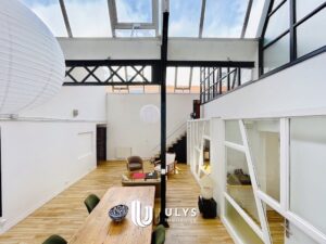 Vue d'intérieur d'un loft parisien haut de gamme à la composition géométrique, soulignant les lignes architecturales, les verrières et les volumes, utilisé pour illustrer la valorisation d'un bien lors d'une estimation immobilière.