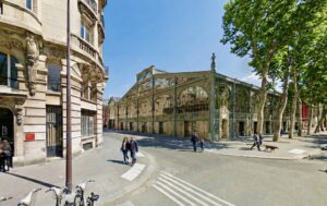 Immeuble haussmannien de prestige faisant face au Carreau du Temple à Paris 3e, situé à l'angle des rues Perrée et Eugène Spuller, illustrant le cadre de vie recherché du Haut-Marais.
